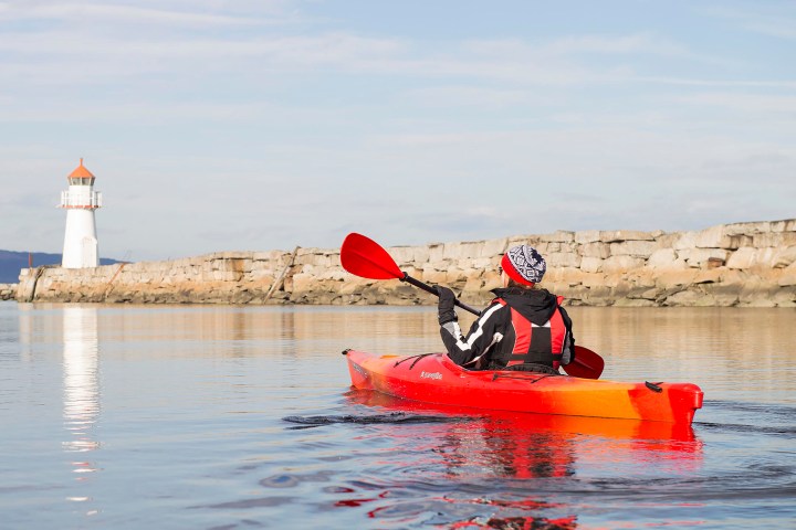 a man riding on the back of a boat in a body of water