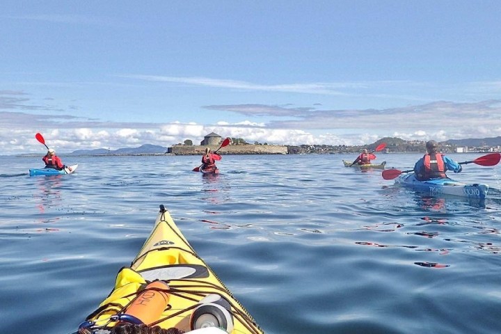 a group of people rowing a boat in the water